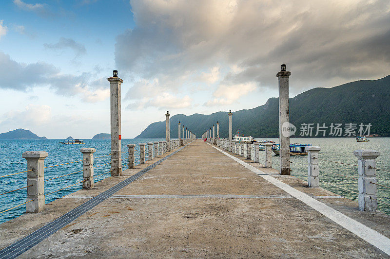 在越南宁静的Con Dao岛上的Con Son镇，新Con Dao客运港口的景色。海岸景观有波浪，海岸线，晴空，碧海，游客和山。